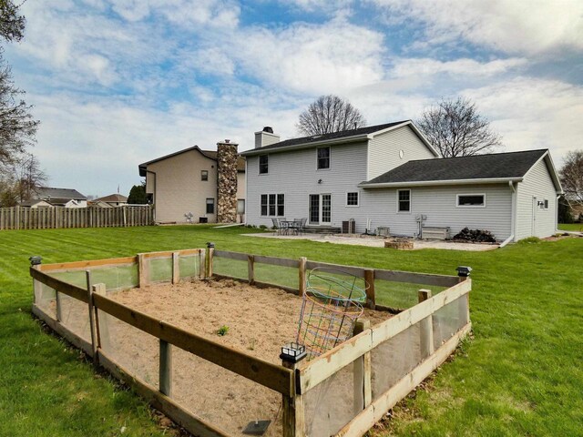 back of property featuring central air condition unit, a patio, a chimney, and a yard