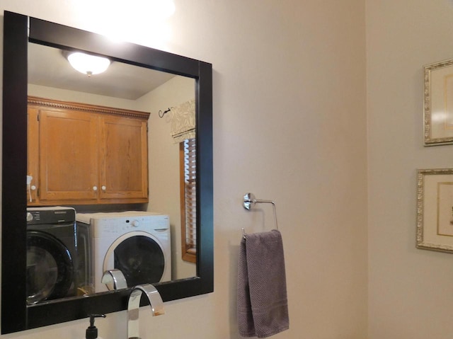 clothes washing area with cabinet space and washer and clothes dryer