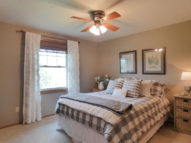 bedroom featuring baseboards, ceiling fan, and light carpet