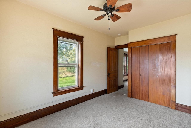 unfurnished bedroom with a ceiling fan, baseboards, carpet, and a closet