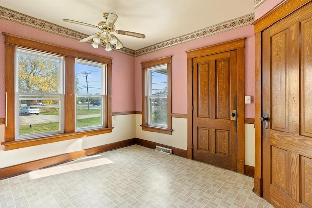 interior space featuring baseboards, visible vents, brick patterned floor, and ceiling fan