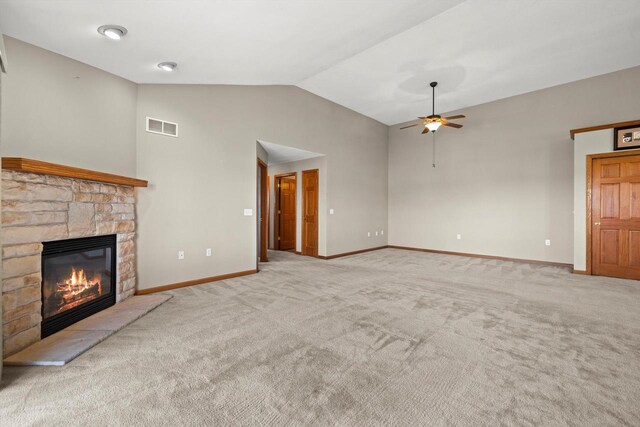 unfurnished living room with a ceiling fan, visible vents, a fireplace, lofted ceiling, and carpet flooring