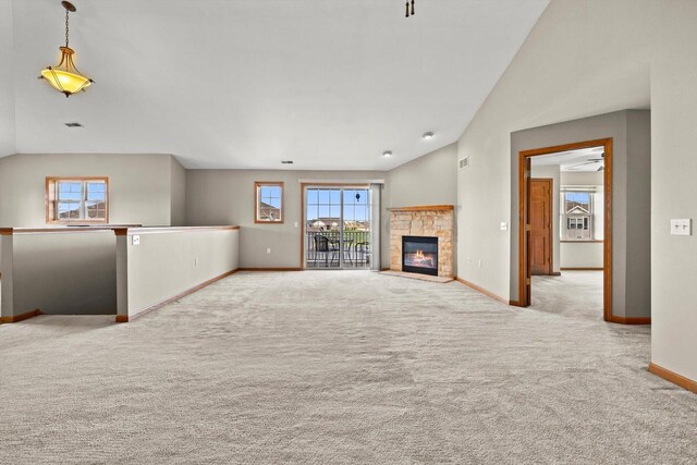 unfurnished living room featuring baseboards, a fireplace, vaulted ceiling, and carpet floors