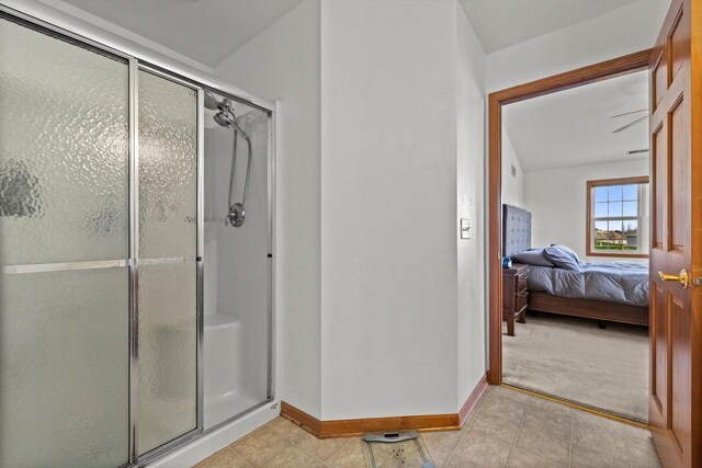 full bathroom featuring baseboards, connected bathroom, tile patterned flooring, and a shower stall