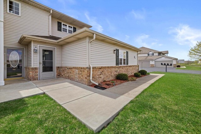 view of side of home featuring a lawn and brick siding