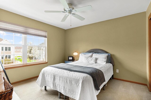 bedroom featuring baseboards, light carpet, and a ceiling fan
