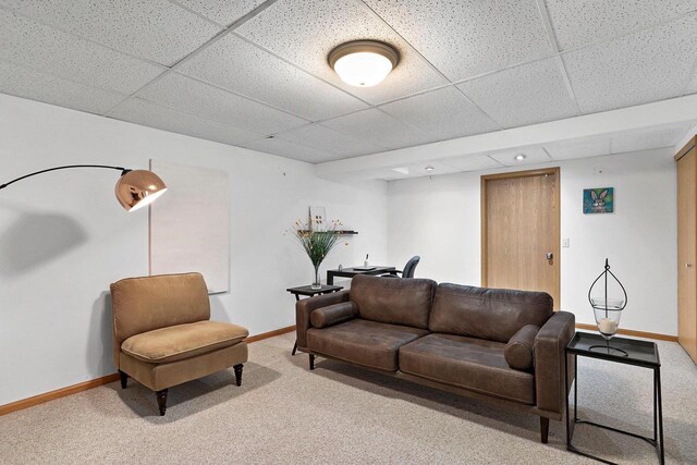 living room with baseboards, carpet, and a drop ceiling