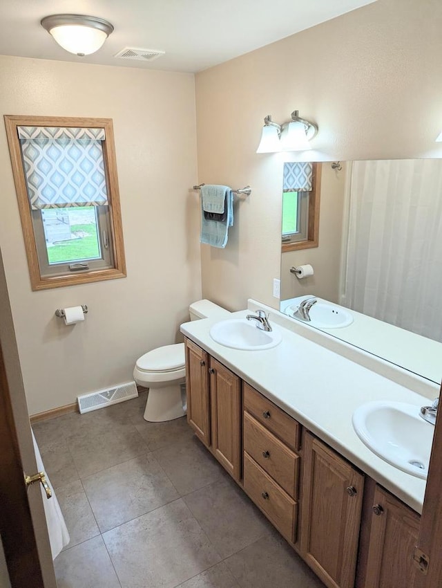 835 Mockingbird Ln, Plymouth, WI 53073 - bathroom with double vanity, toilet, baseboards, and tile patterned floors