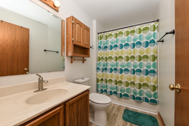 full bath featuring toilet, wood finished floors, shower / bath combo, and vanity