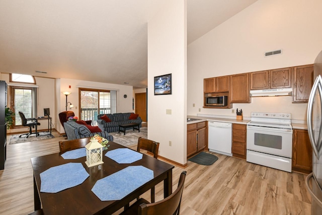 kitchen featuring visible vents, stainless steel appliances, brown cabinets, high vaulted ceiling, and under cabinet range hood