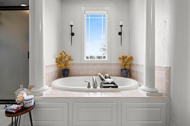 bathroom featuring ornate columns and a garden tub