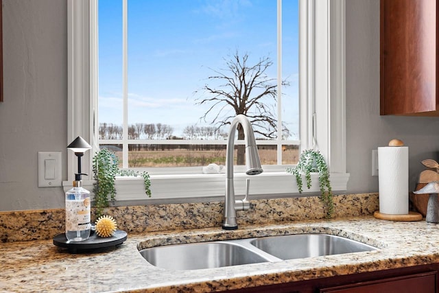 interior details with light stone countertops and a sink