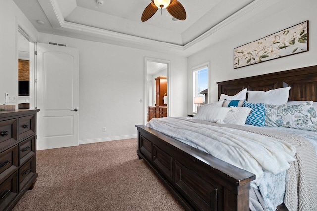 carpeted bedroom with ensuite bathroom, a ceiling fan, a raised ceiling, and baseboards