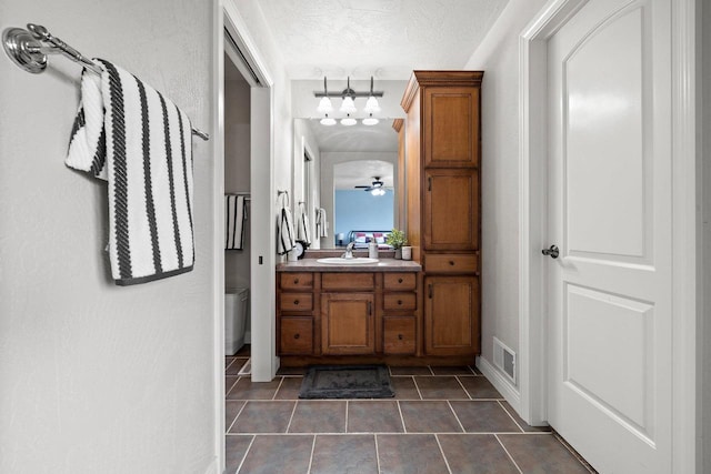 bathroom featuring baseboards, visible vents, tile patterned floors, and vanity