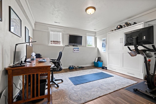 home office featuring visible vents and wood finished floors