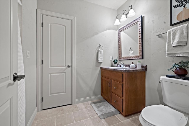 bathroom featuring vanity, baseboards, and toilet