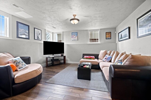 living room featuring visible vents, plenty of natural light, and hardwood / wood-style flooring