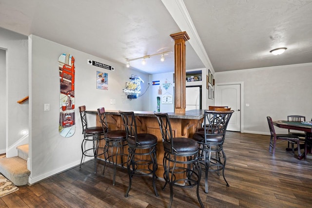 bar with baseboards, a dry bar, freestanding refrigerator, and dark wood-type flooring