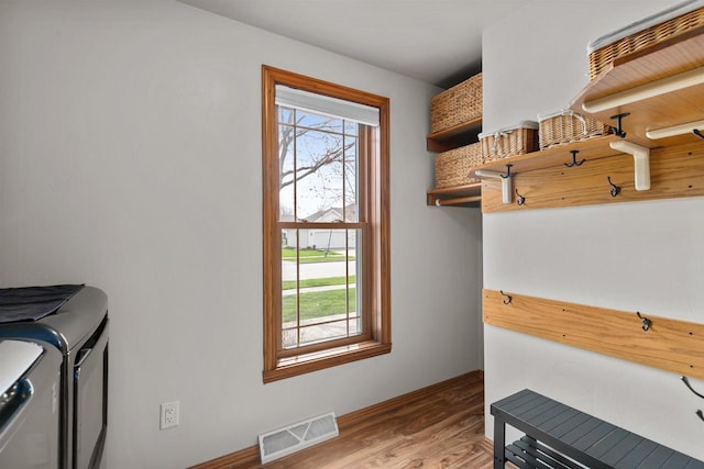 washroom with visible vents, laundry area, washer and dryer, and a healthy amount of sunlight