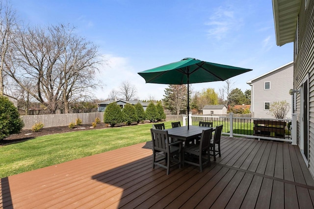 wooden deck featuring a lawn, outdoor dining space, and a fenced backyard