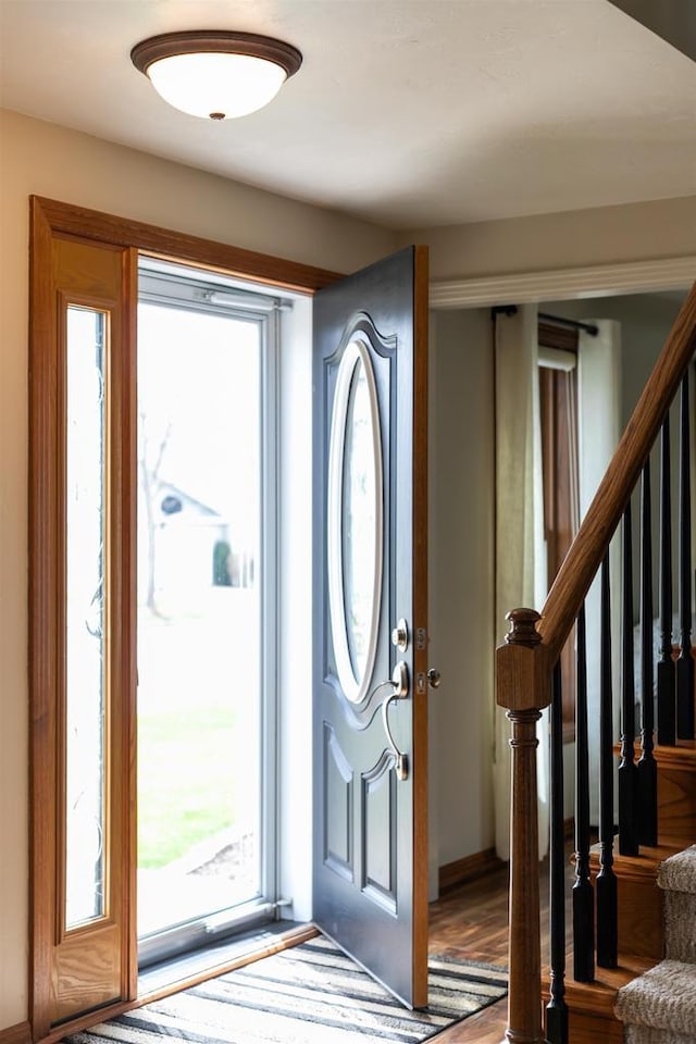 foyer with wood finished floors and stairway