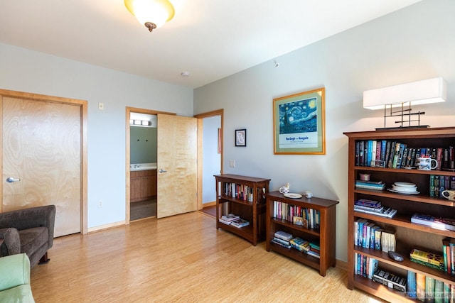 living area with baseboards and wood finished floors
