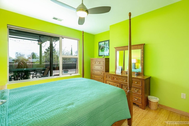 bedroom featuring baseboards, ceiling fan, wood finished floors, and visible vents