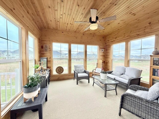 sunroom with an outdoor hangout area, carpet flooring, ceiling fan, and a healthy amount of sunlight
