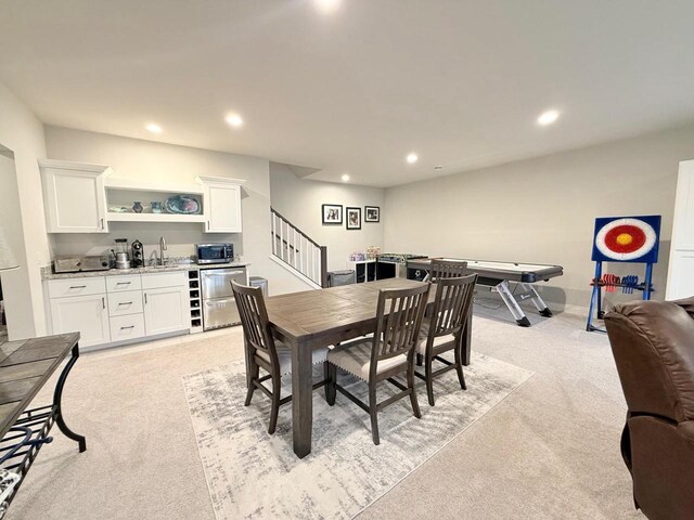 dining area with indoor wet bar, recessed lighting, light colored carpet, and stairway