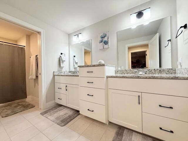 bathroom with tile patterned flooring, a sink, and curtained shower