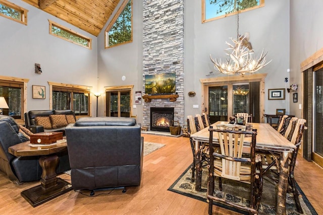 W5929 Driftwood Ln, New Lisbon, WI 53950 - living room featuring high vaulted ceiling, a chandelier, a stone fireplace, wood finished floors, and wooden ceiling