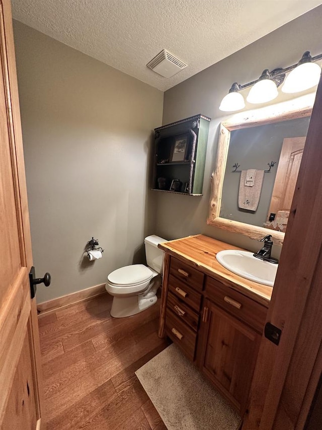 W5929 Driftwood Ln, New Lisbon, WI 53950 - half bath with wood-type flooring, vanity, and a textured ceiling