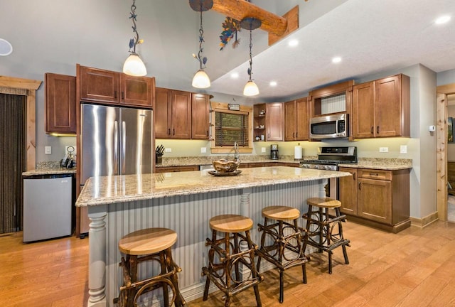 W5929 Driftwood Ln, New Lisbon, WI 53950 - kitchen featuring stainless steel appliances, light wood finished floors, a breakfast bar area, hanging light fixtures, and recessed lighting