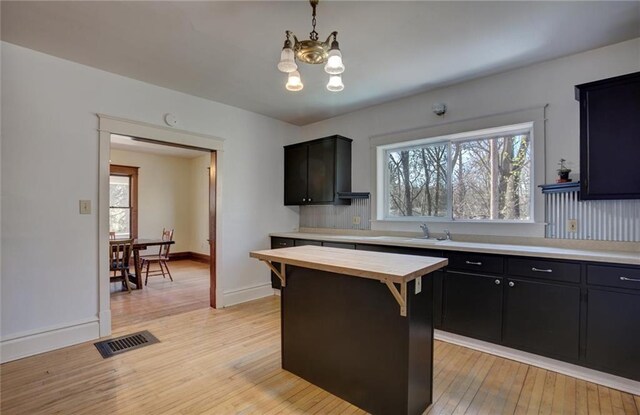 1725 Meadow Hill Dr, Menomonie, WI 54751 - kitchen featuring visible vents, butcher block counters, a chandelier, a sink, and light wood finished floors