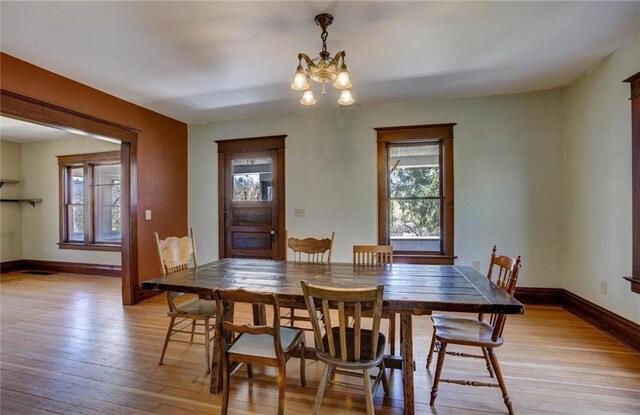 1725 Meadow Hill Dr, Menomonie, WI 54751 - dining area with a healthy amount of sunlight, an inviting chandelier, and light wood-style flooring