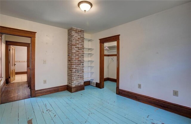1725 Meadow Hill Dr, Menomonie, WI 54751 - unfurnished bedroom with wood-type flooring, baseboards, a closet, and decorative columns