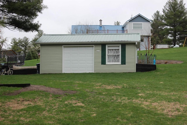 exterior space with a garage, a yard, and metal roof