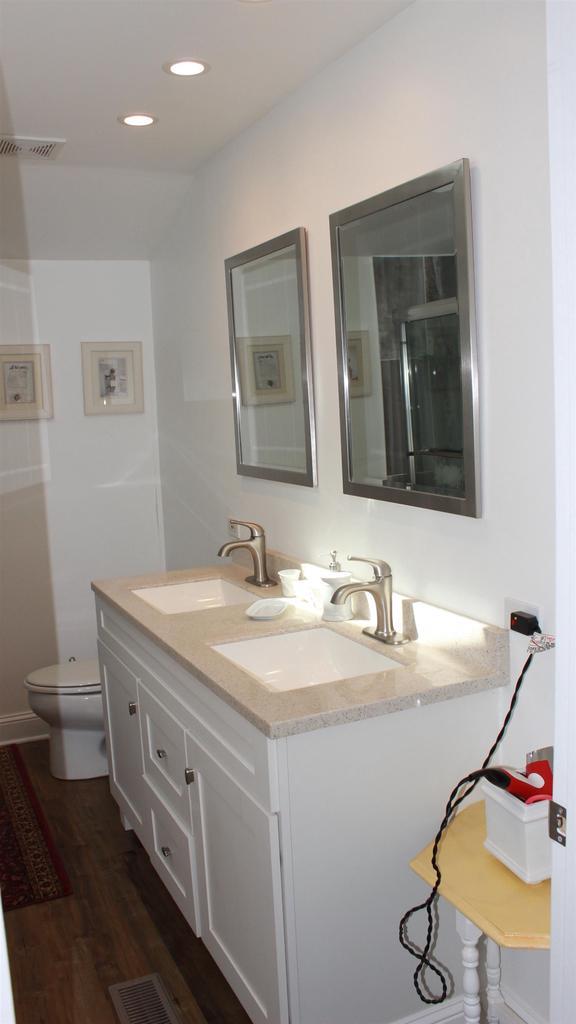 bathroom featuring visible vents, wood finished floors, vanity, toilet, and recessed lighting