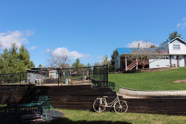 exterior space featuring a lawn, fence, and stairs
