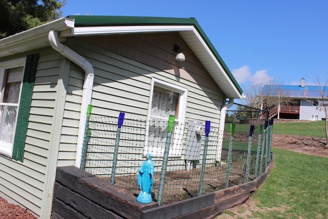 view of home's exterior with a lawn and fence