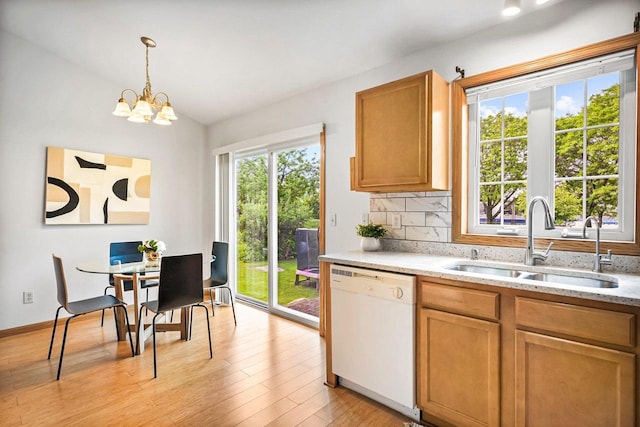 3631 Flagstone Cir, Middleton, WI 53562 - kitchen featuring white dishwasher, a sink, lofted ceiling, light wood-style floors, and pendant lighting