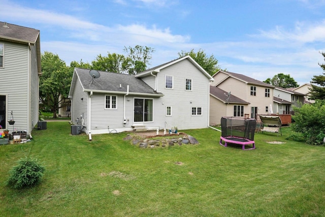 3631 Flagstone Cir, Middleton, WI 53562 - rear view of house with a trampoline, a yard, central AC unit, and a shingled roof