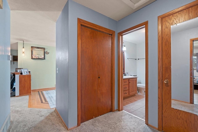 corridor with light colored carpet and baseboards