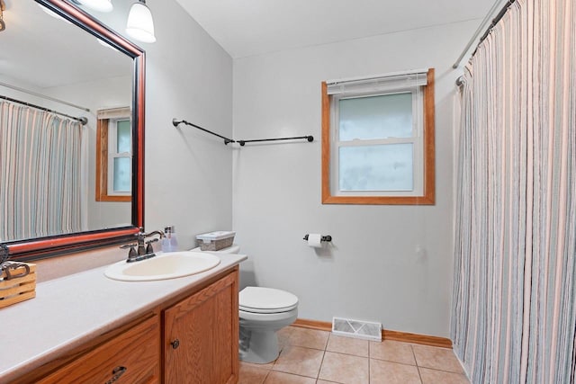 bathroom featuring vanity, toilet, tile patterned floors, baseboards, and visible vents