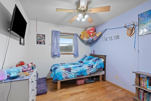 bedroom featuring light wood-style floors, baseboards, and ceiling fan