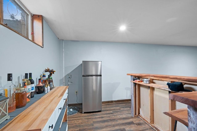 kitchen with dark wood-style flooring, baseboards, freestanding refrigerator, wood counters, and recessed lighting