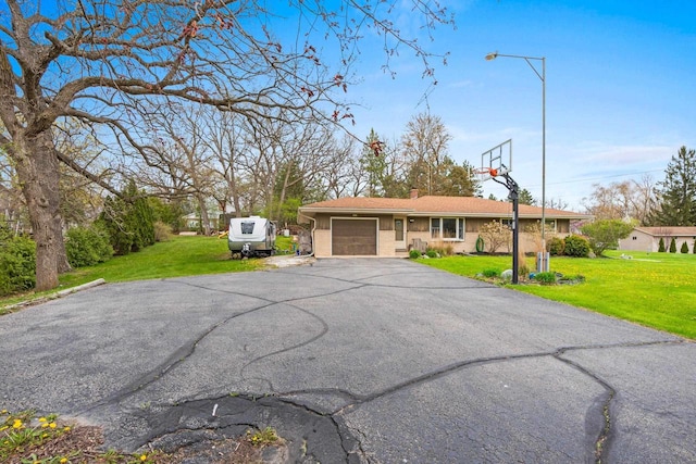 view of front facade with aphalt driveway, a chimney, a front lawn, and a garage