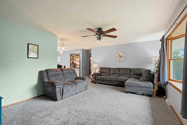living area with carpet floors, ceiling fan, and baseboards