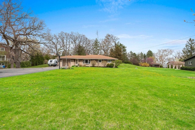 view of front of home with an attached garage, a front lawn, and aphalt driveway