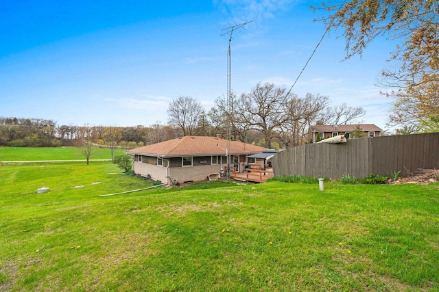 rear view of property with a lawn, fence, a wooden deck, and a chimney